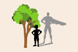 A boy stood in front a tree with a superhero shadow