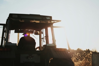 An image of the back of a farmer in a tractor