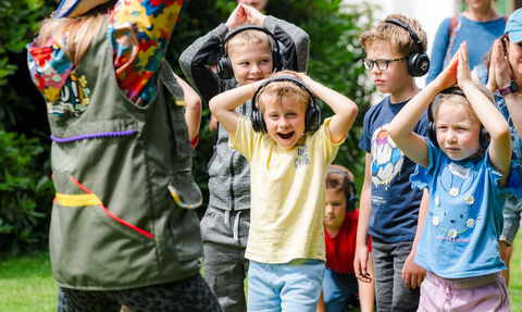 Children in headphones dancing like sharks