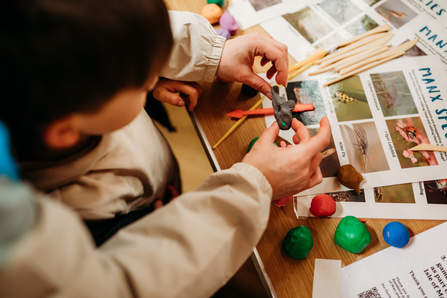 Image of a child and adult playing with modelling clay. 